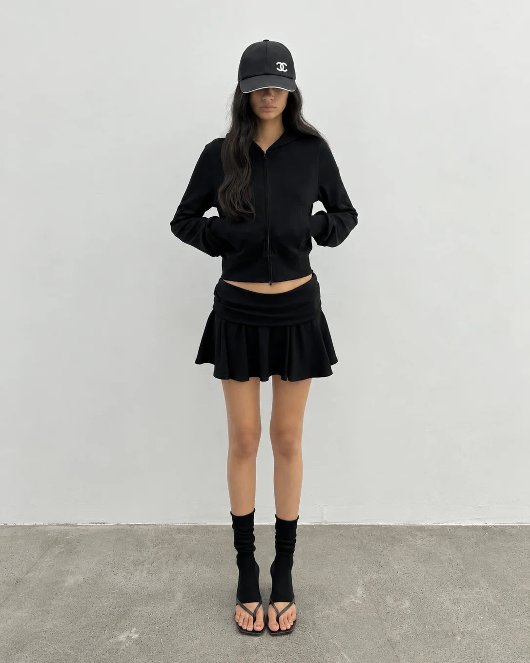 Black hoodie styled with a matching mini skirt